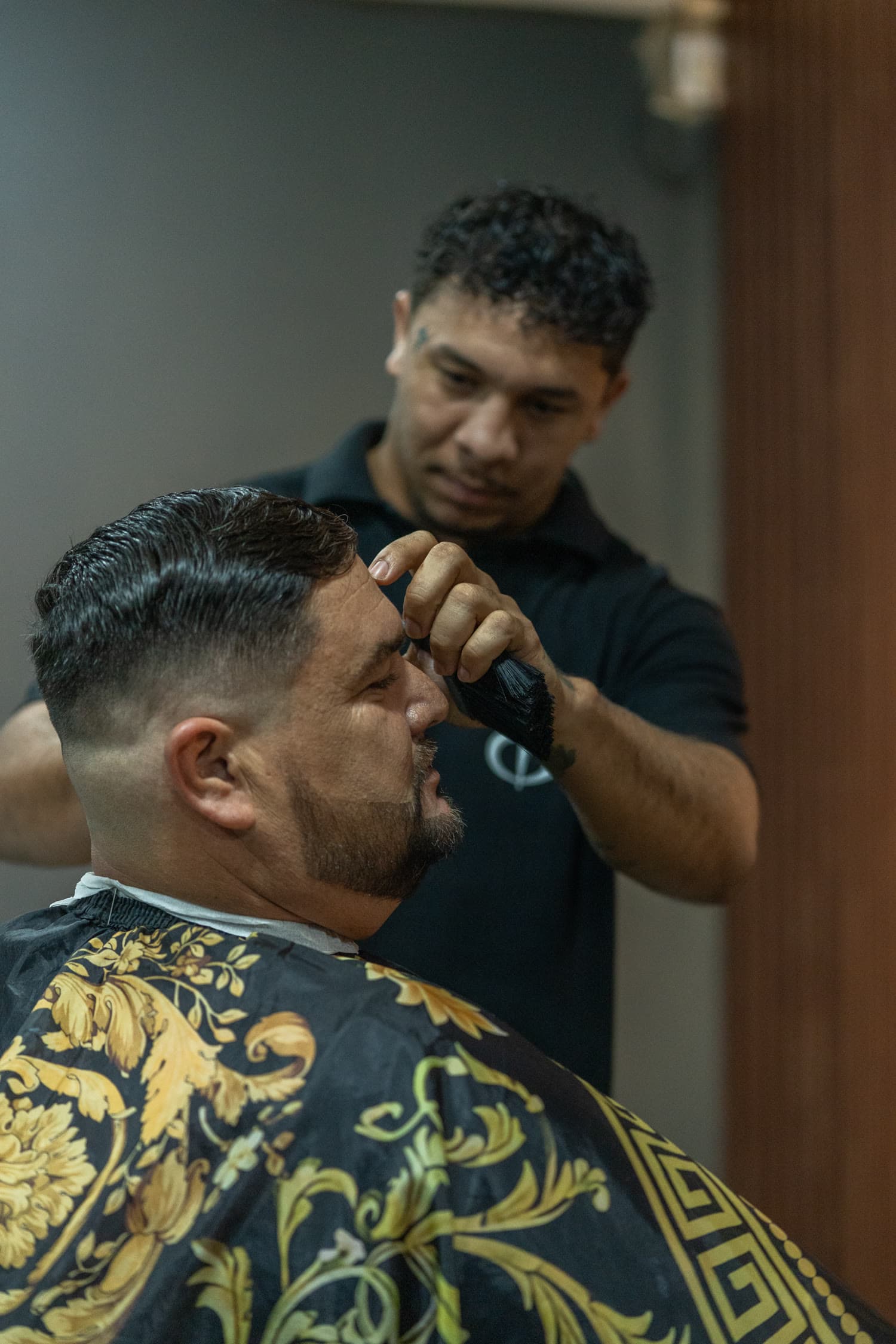 Barbeiro limpando o pescoço do cliente com a escova