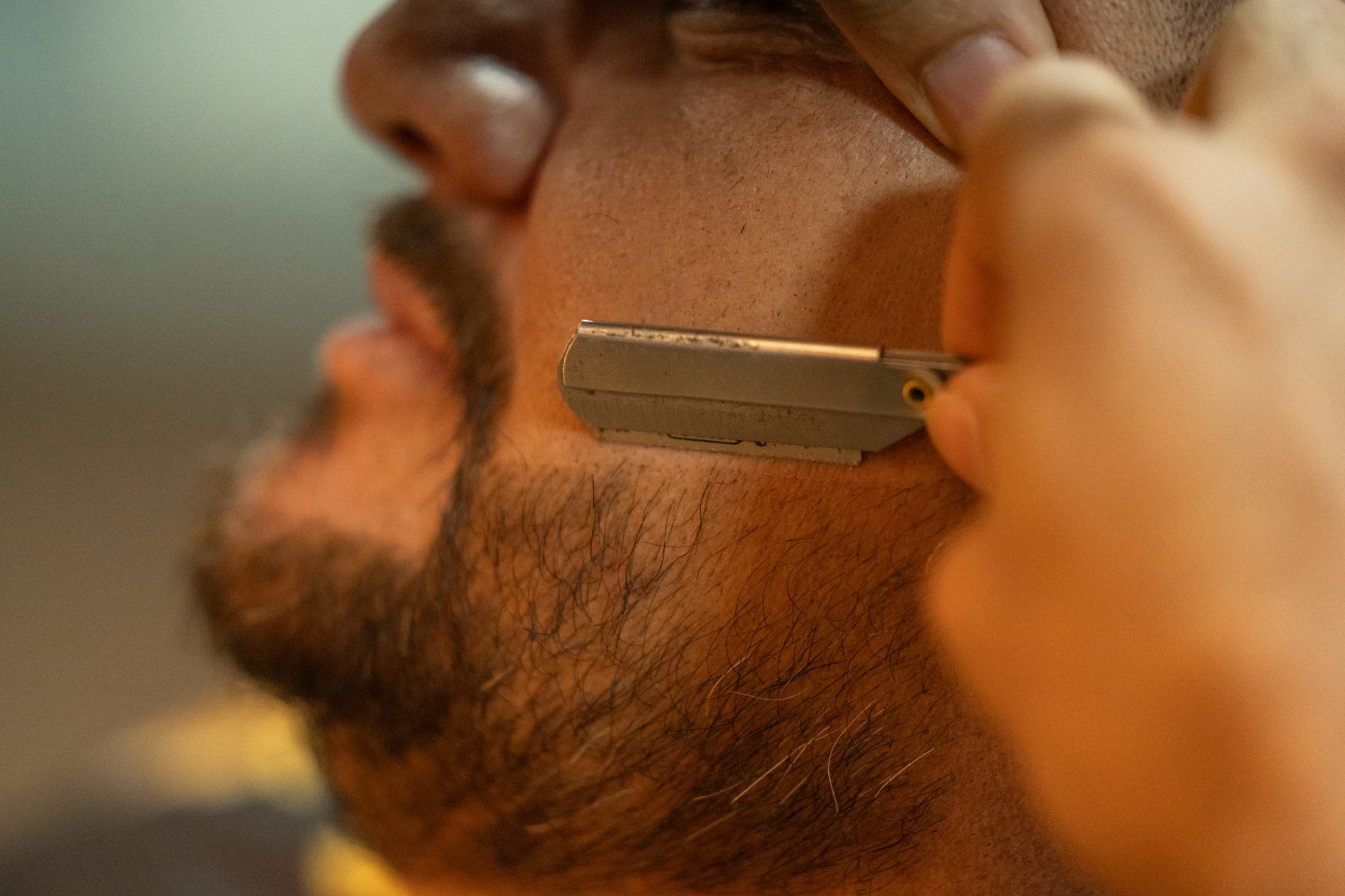 Detalhe da navalha aparando a barba